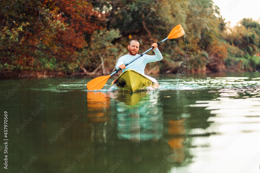 Kayaking on the river. Adult caucasian bearded man floating at the kayak. Copy space. The concept of the World Tourism Day Kayaking on the river. Adult caucasian bearded man floating at the kayak. Copy space. The concept of the World Tourism Day