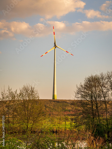 A wind turbine on a small hill near the shore of the River Ruhr between Muelheim an der Ruhr and Oberhausen, North Rhine-Westphalia, Germany photo