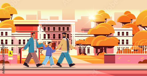 male parents walking with little son gay family transgender love LGBT community concept