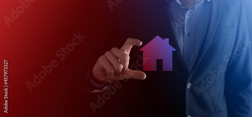 Businessman male hand holding house icon on blue background. Property insurance and security concept.Real estate concept.Banner with copy space.
