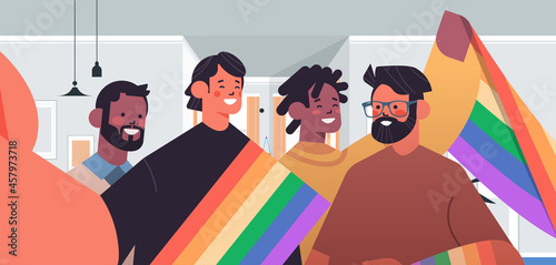 mix race gays with rainbow flag taking selfie photo on smartphone camera transgender love LGBT community