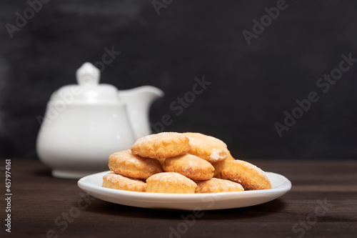 Shortbread cookies on white plate on wooden table, side view. Baking for tea, Fresh pastry photo