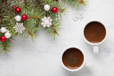 Two cups of coffee and  spruce branch with Christmas decorations on old wooden shabby background.