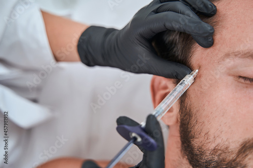 Male patient getting a face filler injection