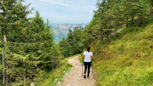 Female hiker in the Alps of Allgäu Bavaria Germany with hiking ploes with mountain panorama in the background, Hochalp close to Pfronten