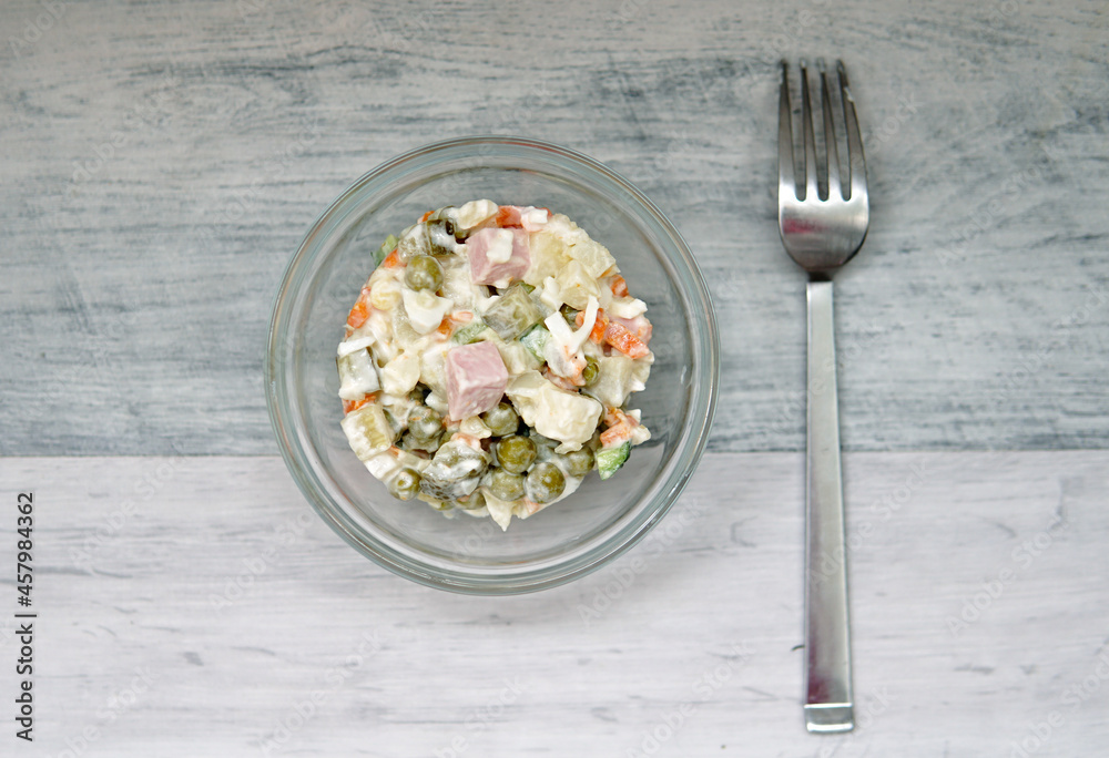 Russian New Year or Christmas salad on light background with copy space. Top view, flat lay