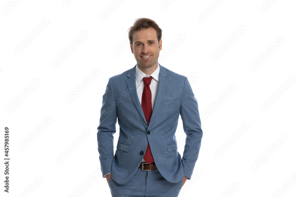 portrait of happy businessman in blue suit holding hands in pockets portrait of happy businessman in blue suit holding hands in pockets