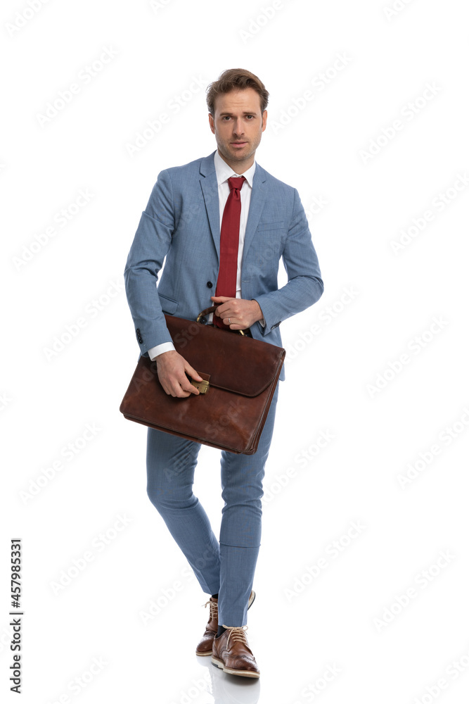 sexy young guy in blue suit holding and opening suitcase while walking sexy young guy in blue suit holding and opening suitcase while walking
