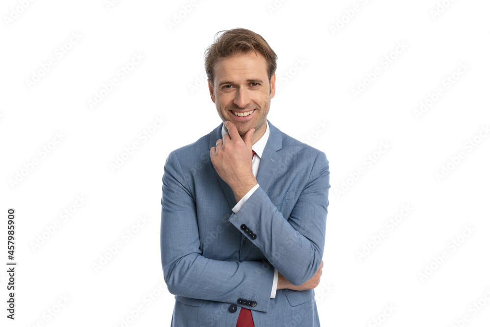 happy young businessman crossing arms, touching chin and smiling happy young businessman crossing arms, touching chin and smiling