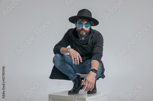 sexy casual guy posing in a squatted position