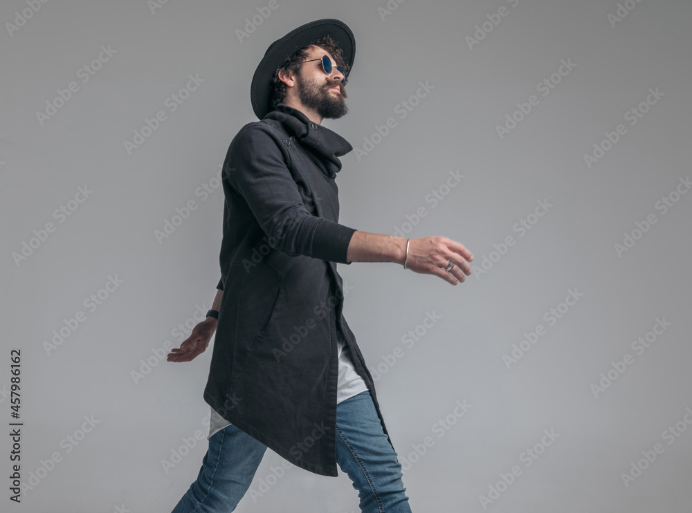 handsome casual man walking with attitude and wearing sunglasses handsome casual man walking with attitude and wearing sunglasses