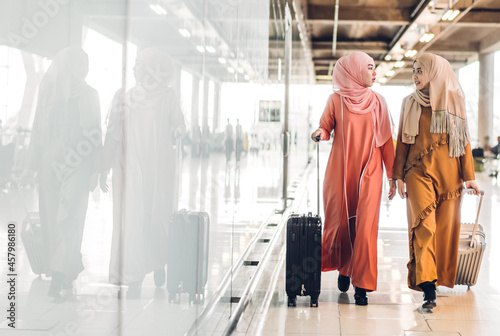 Two young beauty islamic asian arabic muslim woman wearing a hijab enjoying shopping and having fun talking together in the shop at fashion store