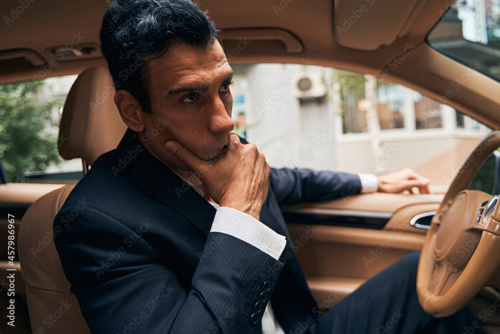 Businessman checking his appearance in automobile mirror Businessman checking his appearance in automobile mirror