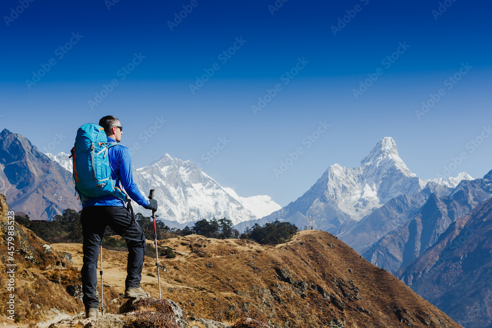 Hiker with backpack enjoying the Ama Dablam mountain view view Everest trek in Himalayas. Success, freedom, active sport concept
