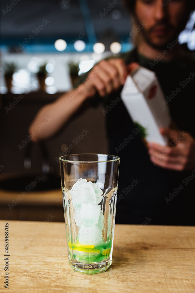 Making a green cocktail in a glass glass at a bar - lemon and banana syrup Making a green cocktail in a glass glass at a bar - lemon and banana syrup