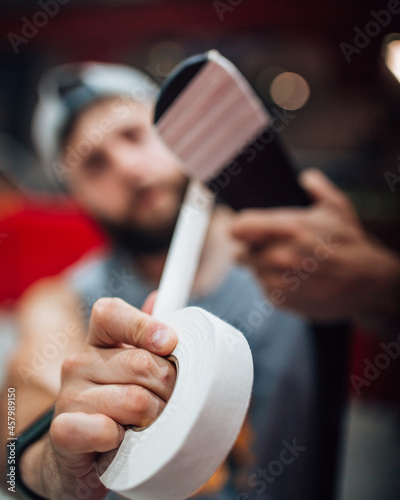 Canvas Print Close-up of a man hand with a white tape to protect a playing hockey stick for t