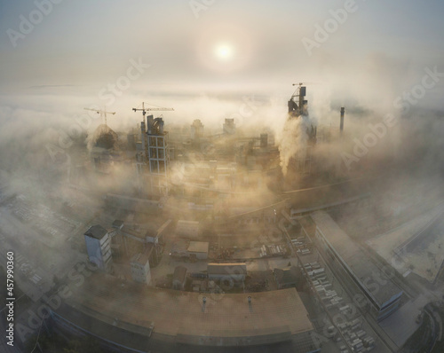 Industrial plant at sunrise in the fog