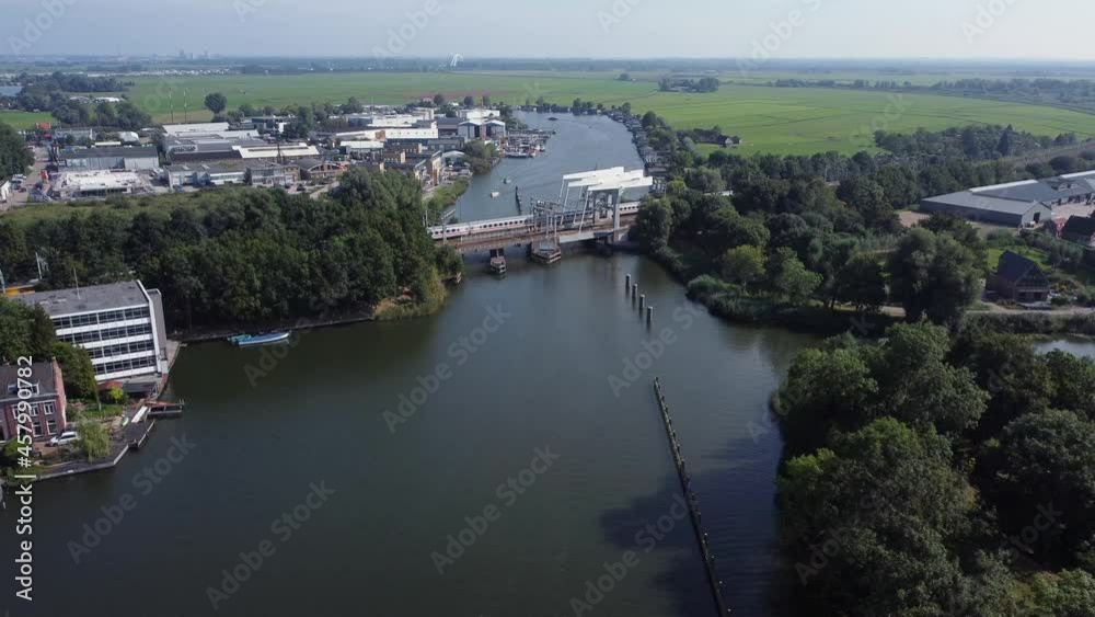 Railway bridge over river Vecht in Holland in the city of Weesp, Dutch yellow train passing Railway bridge over river Vecht in Holland in the city of Weesp, Dutch yellow train passing