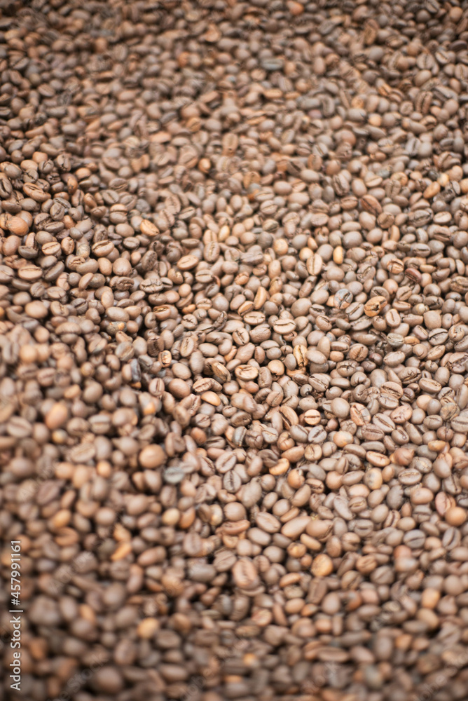 Close-up of roasted coffee beans. Fresh aromatic coffee ready for sale. Production, industry, manufacturing process concept Close-up of roasted coffee beans. Fresh aromatic coffee ready for sale. Production, industry, manufacturing process concept