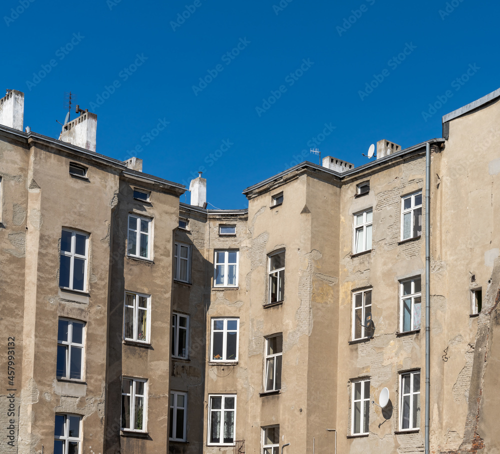 run-down and shabby apartment building block in Eastern Europe under a blue sky