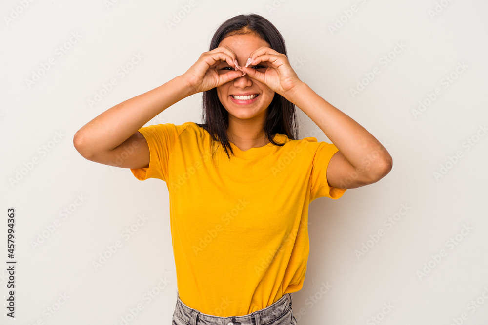 Young latin woman isolated on white background showing okay sign over eyes Young latin woman isolated on white background showing okay sign over eyes