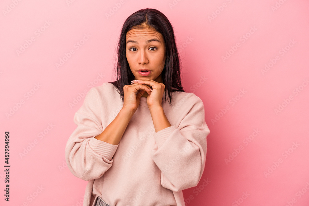 Young latin woman isolated on pink background praying for luck, amazed and opening mouth looking to front. Young latin woman isolated on pink background praying for luck, amazed and opening mouth looking to front.