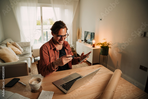 Caucasian male business man working from home making online payment sitting at home desk