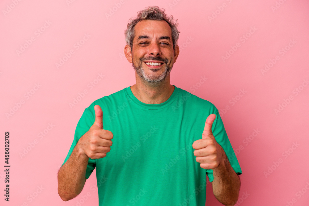Middle age caucasian man isolated on pink background smiling and raising thumb up Middle age caucasian man isolated on pink background smiling and raising thumb up