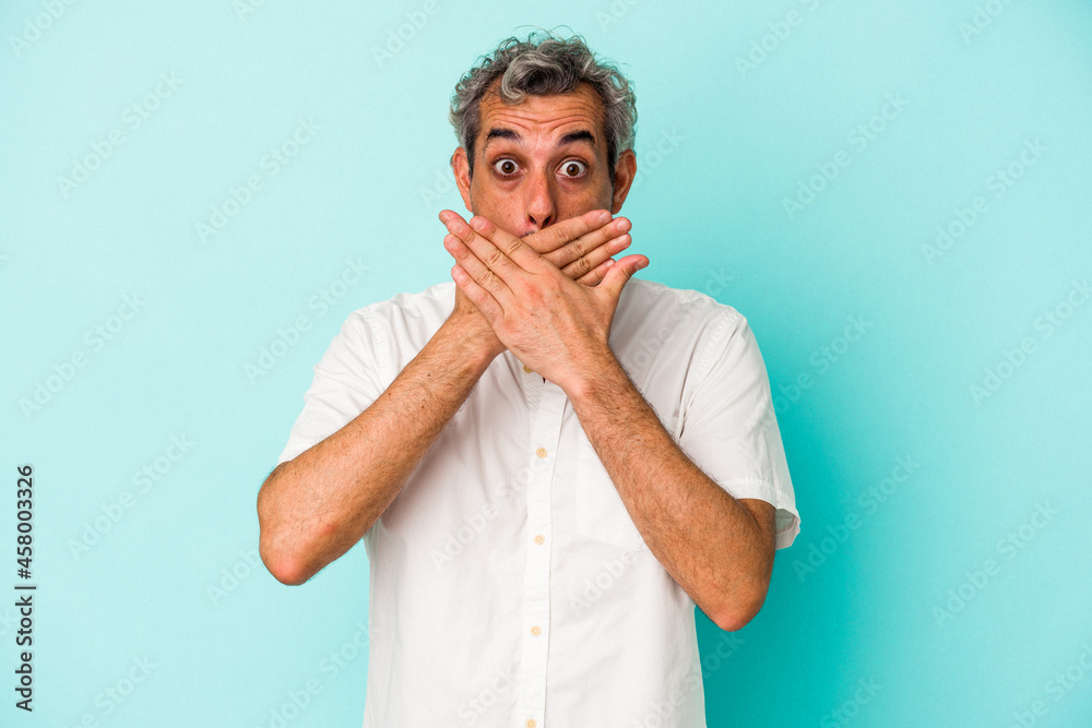 Middle age caucasian man isolated on blue background covering mouth with hands looking worried. Middle age caucasian man isolated on blue background covering mouth with hands looking worried.