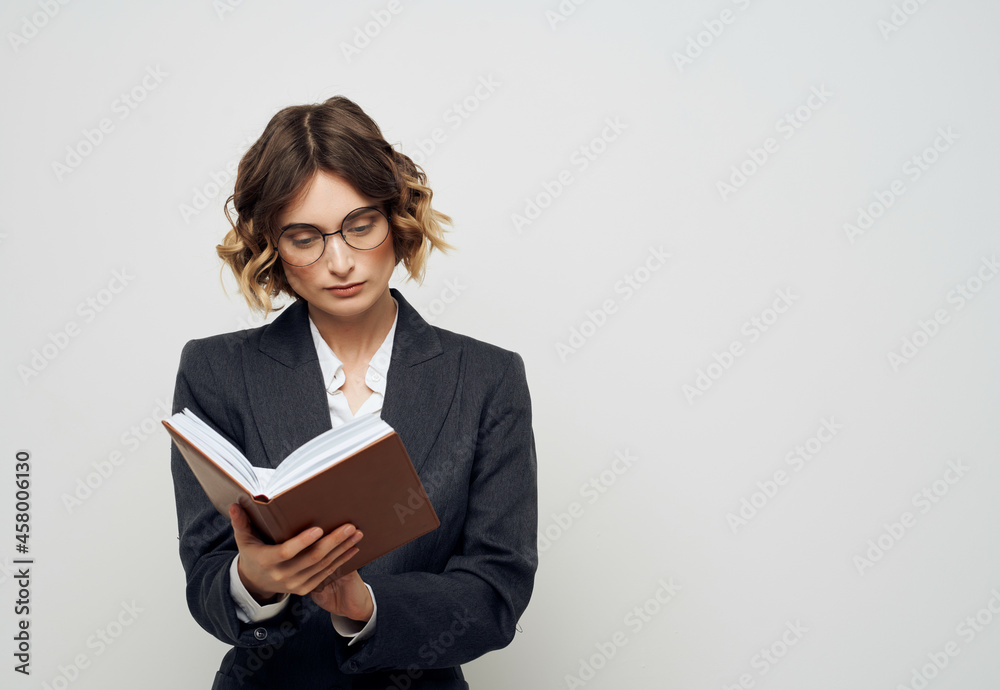 woman in business suit with a book in his hands light background woman in business suit with a book in his hands light background