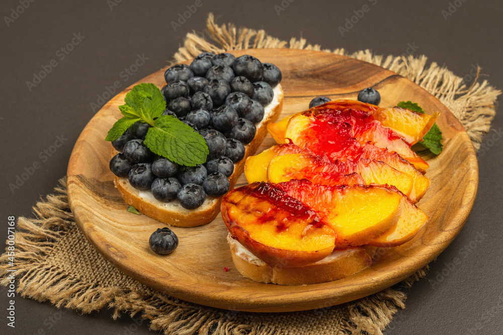 Tasty toast bread with cream cheese and ripe fruits