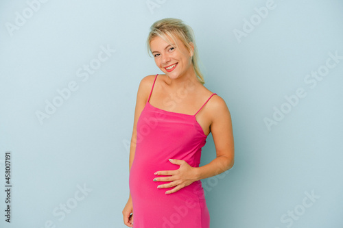 Young Russian woman pregnant isolated on blue background happy, smiling and cheerful.