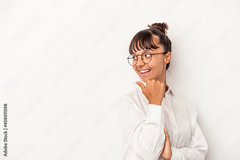 Young mixed race business woman isolated on white background  points with thumb finger away, laughing and carefree.