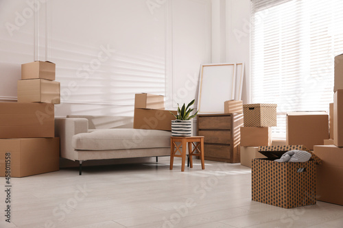 Furniture and cardboard boxes with packed stuff in room. Moving day © New Africa