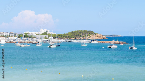Recreational boats and fishing boats in front of the port of Santa Eularia des Riu on the island of Ibiza. Heavenly views of the sea with turquoise color on a sunny day. 