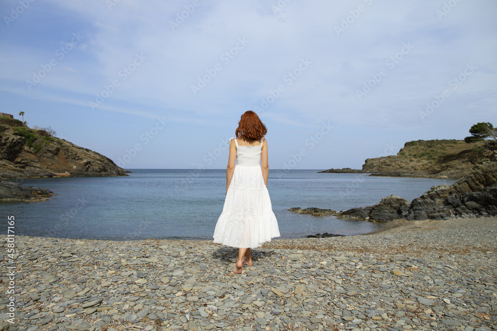 Full body of woman walking contemplating on the beach Full body of woman walking contemplating on the beach