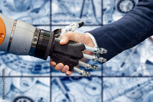 Hand of a businessman shaking hands with a Android robot.