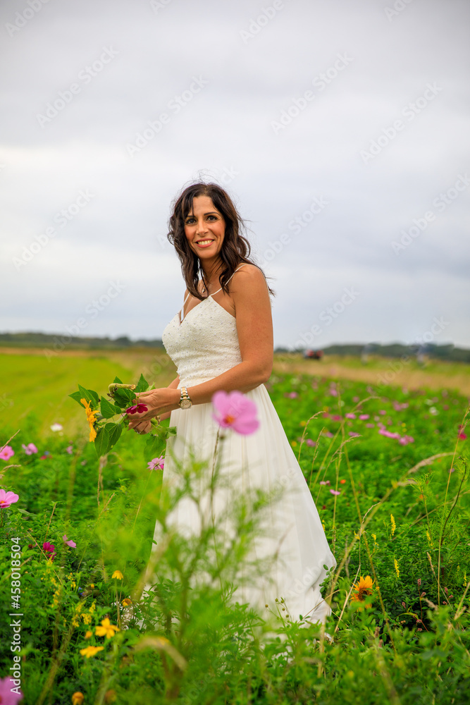 Junge hübsche Frau im Brautkleid in einer Blumenwiese Junge hübsche Frau im Brautkleid in einer Blumenwiese