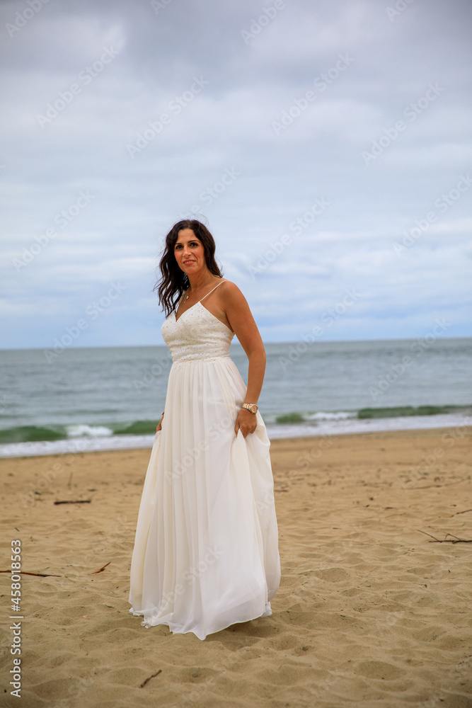 Junge schöne Braut im Hochzeitskleid am Meer Junge schöne Braut im Hochzeitskleid am Meer