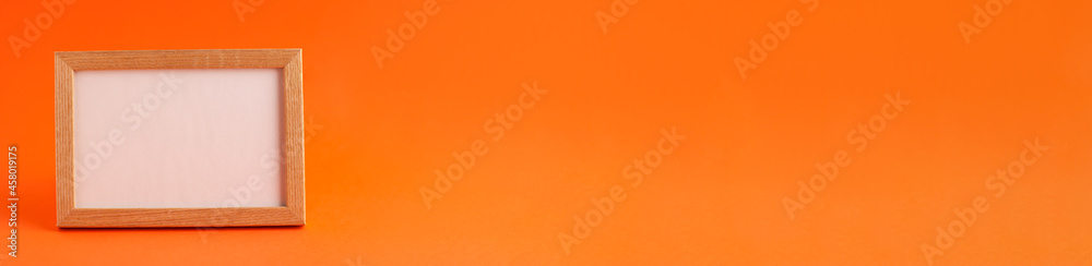 Fototapeta premium Close up banner of mockup template white frame with wooden borders on orange blurred background and copy space. Holiday autumn concept backdrop