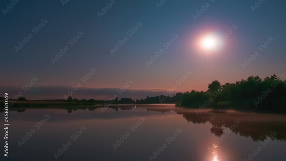 Starry night on a calm lake with flat water surface. Stars and moon timelapse Starry night on a calm lake with flat water surface. Stars and moon timelapse
