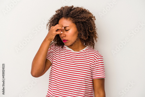 Young african american woman with curly hair isolated on white background having a head ache, touching front of the face.