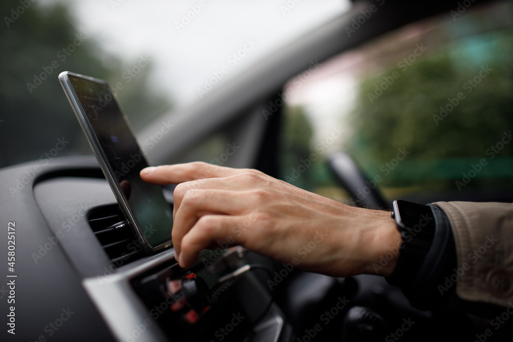 Navigator in car vehicle transportation commuter. Driver man using mobile phone navigator app while driving car vehicle Navigator in car vehicle transportation commuter. Driver man using mobile phone navigator app while driving car vehicle