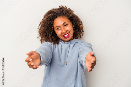Young african american woman with curly hair isolated on white background showing a welcome expression.