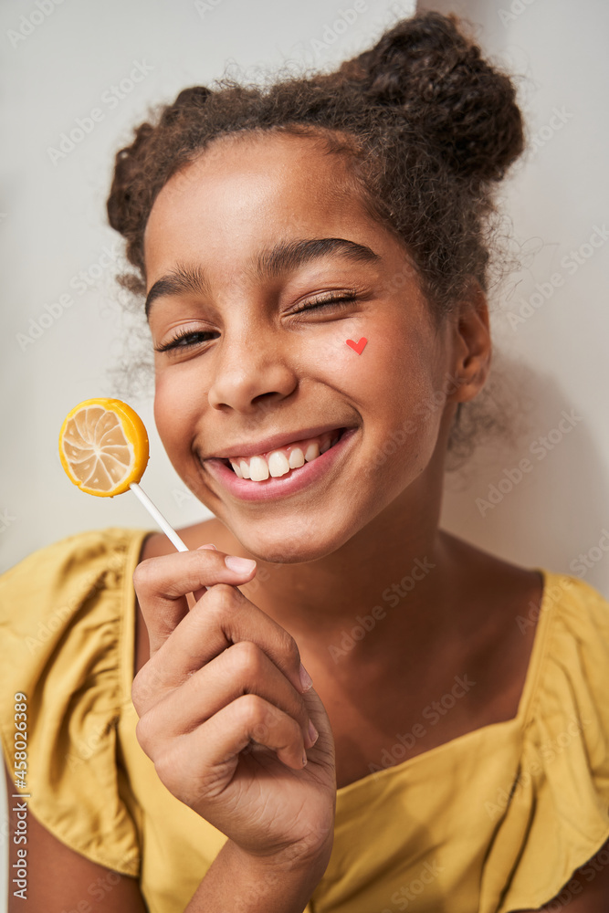 Girl holding sweet lollypop with happy expression and smiling to the camera Girl holding sweet lollypop with happy expression and smiling to the camera