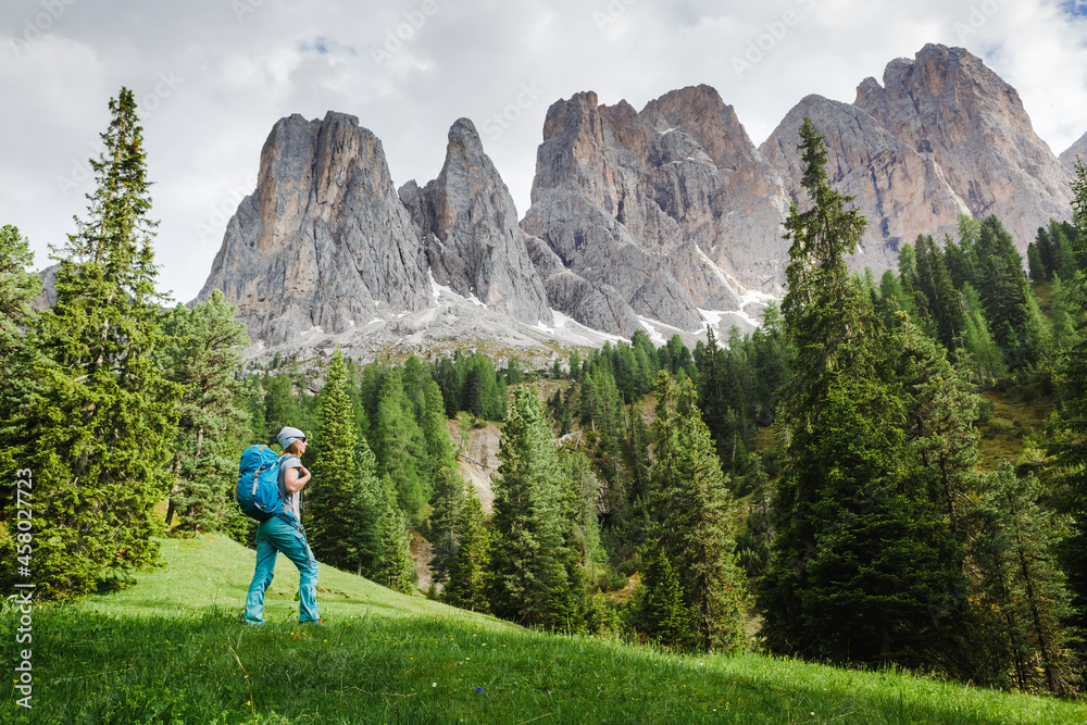 Hiker woman enjoying the views over The Dolomites in italy Hiker woman enjoying the views over The Dolomites in italy