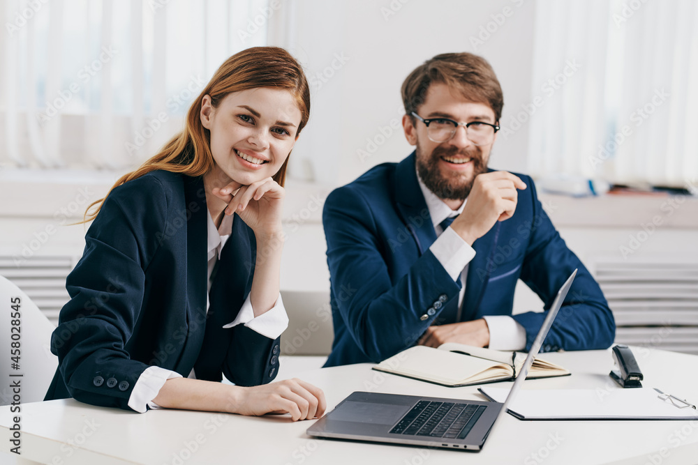 man and woman managers work together in front of laptop office technology man and woman managers work together in front of laptop office technology