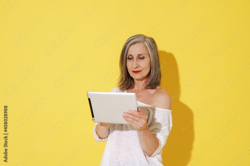 White senior woman with grey hair using tablet computer White senior woman with grey hair using tablet computer