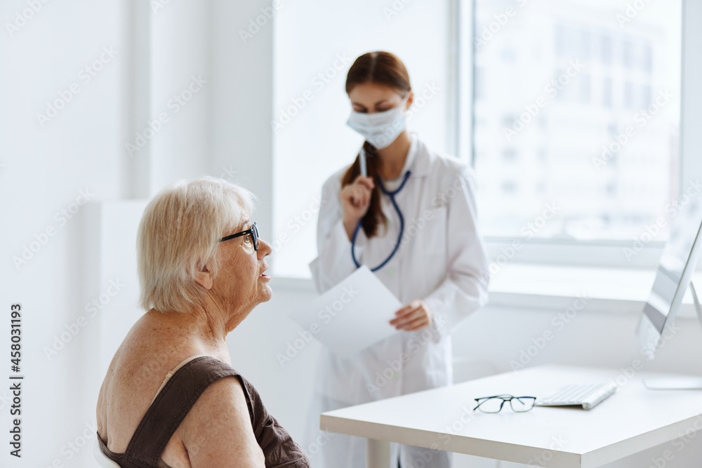 elderly woman wearing a medical mask communicates with the doctor health diagnostics elderly woman wearing a medical mask communicates with the doctor health diagnostics