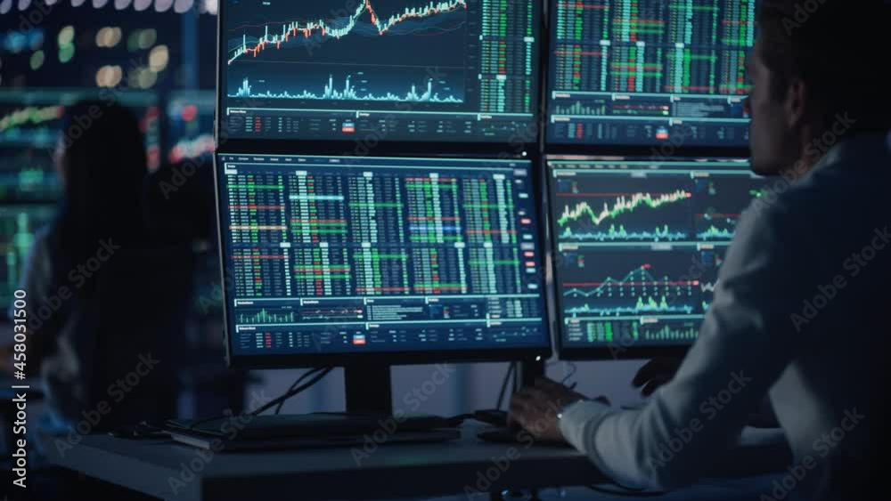 Financial Analysts and Day Traders Working on a Computers with Multi-Monitor Workstations with Real-Time Stocks, Commodities and Exchange Market Charts. Team of Brokers at Work in Agency. Rack Focus. Financial Analysts and Day Traders Working on a Computers with Multi-Monitor Workstations with Real-Time Stocks, Commodities and Exchange Market Charts. Team of Brokers at Work in Agency. Rack Focus.
